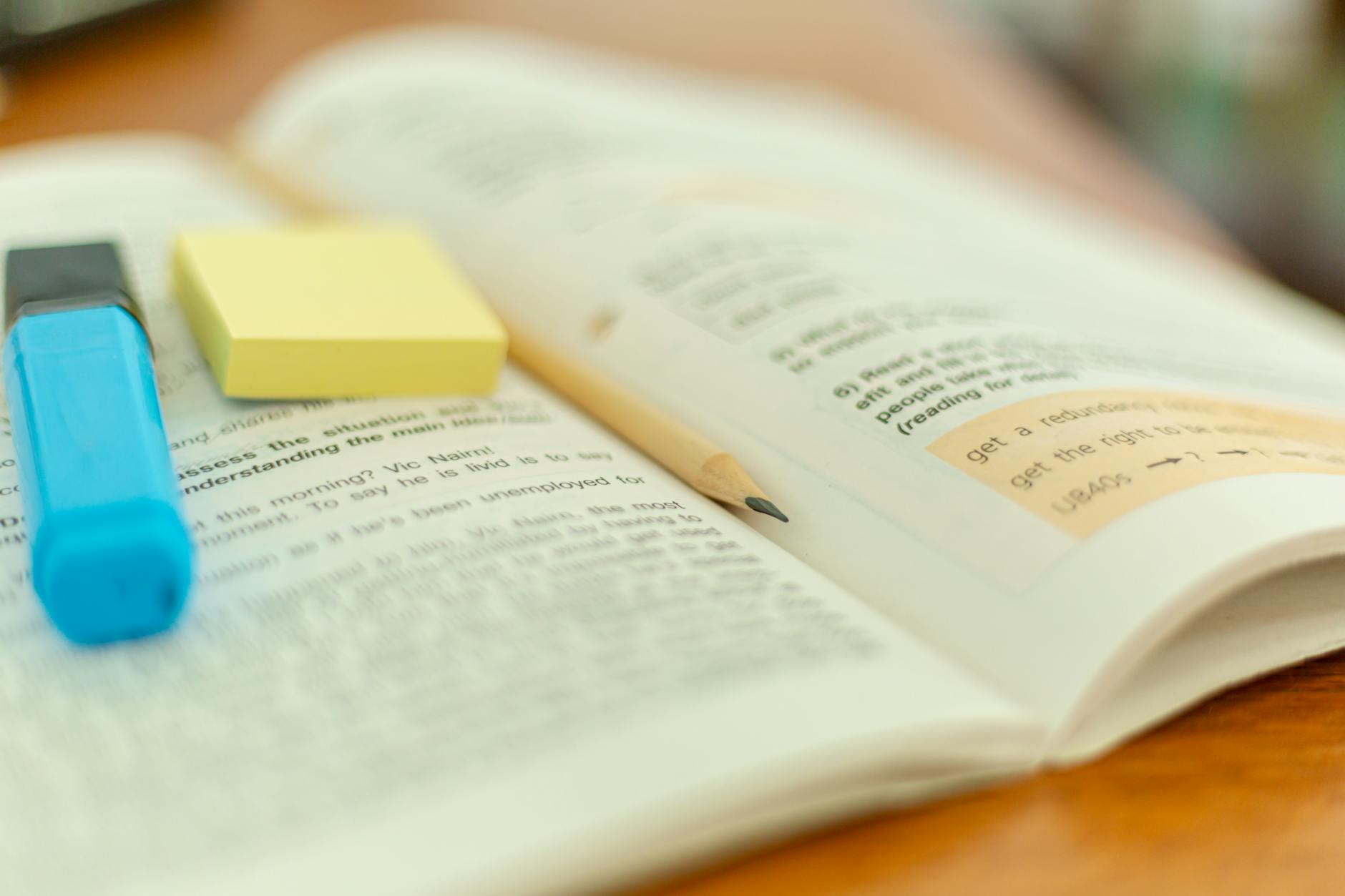 An open textbook with highlighter and handwritten notes, illustrating passive review versus active recall