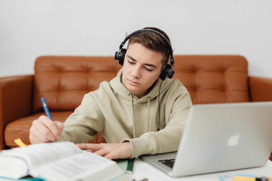 Teen studying with laptop and headphones